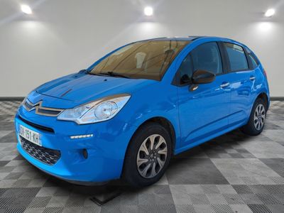 a blue citrole is parked in a room with a checkered floor