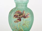 un vase vert sur lequel est peinte une fleur