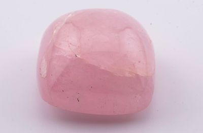 gros plan d'une pierre rose sur une surface blanche