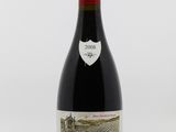 une bouteille de vin rouge posée sur une table blanche