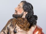 a figurine of a man holding a child