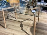 une table en verre avec un plateau en verre posée sur un parquet