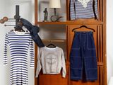 une armoire avec des vêtements et une chaise dans un coin