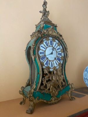 une horloge posée sur une étagère à côté d'une assiette