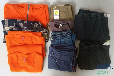 plusieurs paires de vêtements masculins sont disposées sur une table
