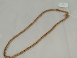 a close up of a gold chain on a white surface