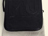a black marc jacobs bag sitting on top of a white cloth