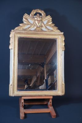 a mirror that is sitting on a wooden stand