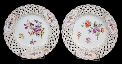 deux assiettes blanches ornées de motifs floraux sur un fond noir