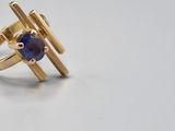 an image of a gold ring with a blue stone