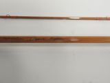 two wooden fishing rods with writing on them sitting on top of a table