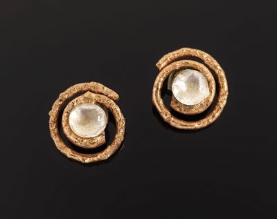a pair of gold and pearl earrings on a black surface