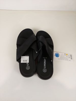 des chaussons noirs ornés d'un nœud sur le côté, posés sur un fond blanc