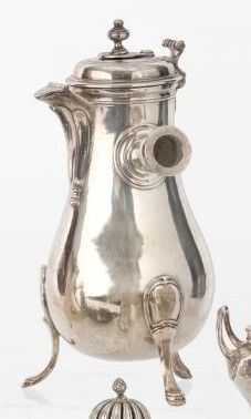 une théière en argent et deux théières en argent posées sur une table