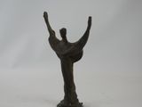 bronze statue of a woman holding her hands up in the air