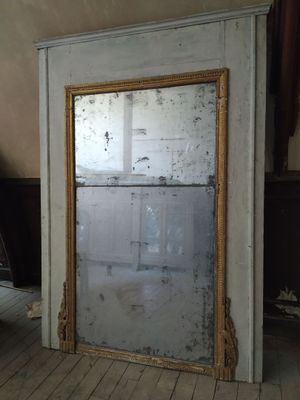 un grand miroir posé sur le sol d'une pièce