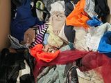 a cardboard box filled with clothes and clothes on the floor