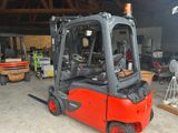 a red forklift truck parked in a garage