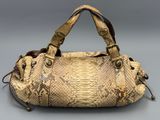 an image of a snake skin handbag on a gray background
