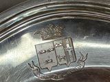 a silver plate with a coat of arms on it