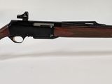 un gros plan d'un fusil posé sur un support transparent, sur une surface blanche