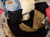a basket full of clothes that is sitting on the floor