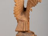 wooden sculpture of a bird on a rock on a table