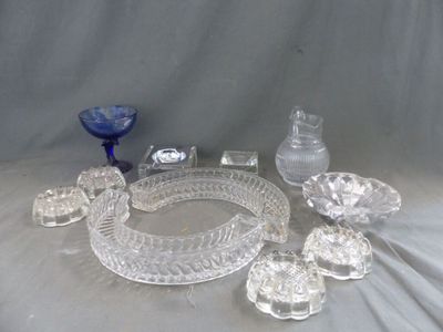 de nombreux objets en verre posés sur une table, sur fond gris