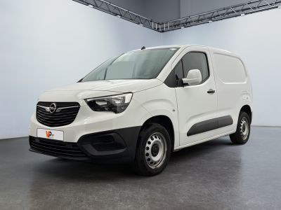 La camionnette blanche est garée dans une grande pièce.