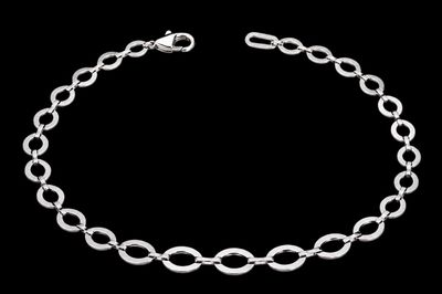 un gros plan d'un bracelet à chaîne argentée sur fond noir