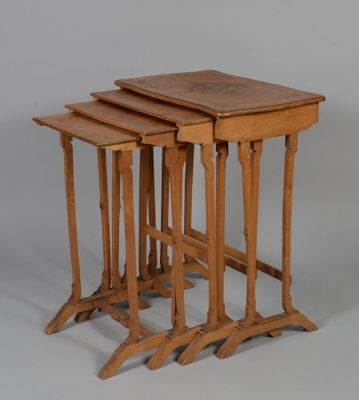 trois tables gigognes en bois empilées les unes sur les autres sur une surface grise