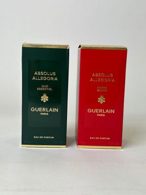 two boxes of perfume sitting next to each other on a white surface