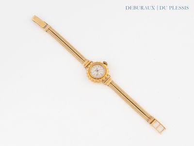 un gros plan d'une montre sur une surface blanche avec un fond blanc