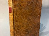 an old book sitting on top of a table with a piece of paper sticking out of it