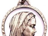 un gros plan d'un pendentif en argent représentant le visage d'une femme dans un cercle