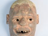 a clay mask with a smile on it ' s face