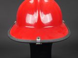 an image of a red fireman ' s helmet on a black background