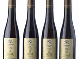 three bottles of wine sitting next to each other on a white surface