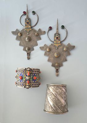 trois pièces d'argent sont accrochées au mur, à côté d'un vase