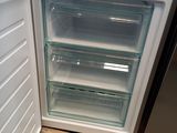 an open refrigerator that is sitting on a wooden floor