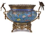 un vase bleu orné d'oiseaux, surmonté d'un oiseau