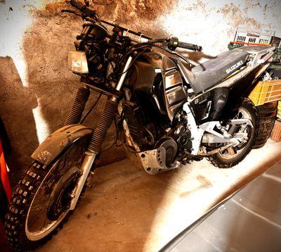 une moto garée dans un garage à côté d'une voiture