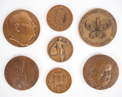 six pièces de bronze présentant différents motifs sur un fond blanc