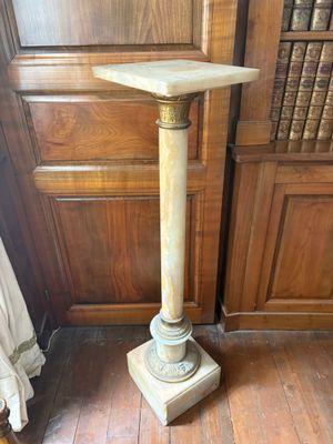 un socle en marbre dans un coin d'une pièce