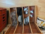 a wooden box with plates and cups in it