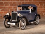a vintage car that is parked in front of a brick wall