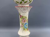un vase blanc avec des fleurs sur une table