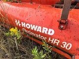 a red tractor that is parked in the grass