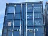 two blue shipping containers stacked on top of each other in a parking lot