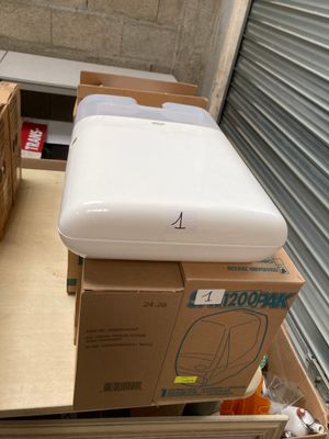 un réfrigérateur blanc posé sur des cartons dans une pièce